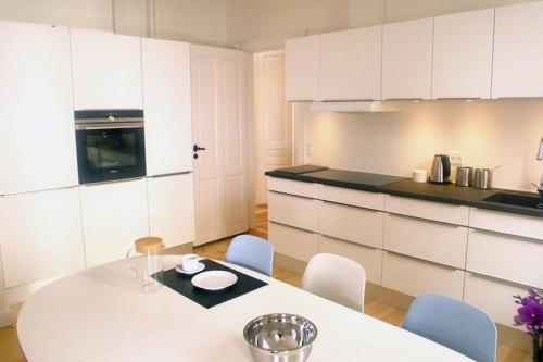 a white kitchen with a white table and chairs at Next to New Harbor / 3 BR & 2 Bath Rooms in Copenhagen