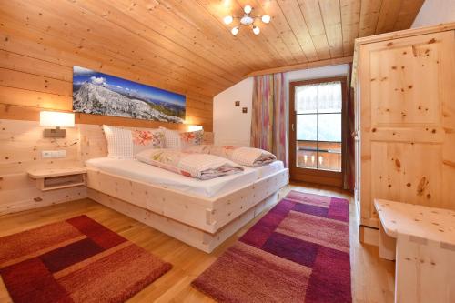 een slaapkamer met een bed in een houten kamer bij Ferienwohnung Fiel in Sankt Gallenkirch