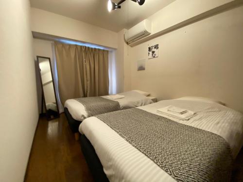 um quarto de hotel com duas camas e uma janela em Residential Hotel Bevel Tokyo em Tóquio