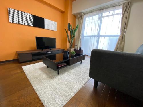 a living room with a couch and a television at Residential Hotel Bevel Tokyo in Tokyo