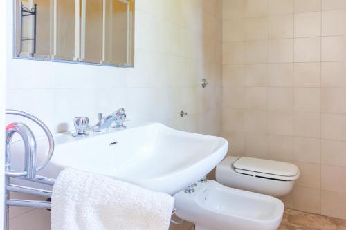 Baño blanco con lavabo y aseo en Depéndance en Polignano a Mare