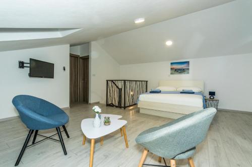 Un dormitorio con una cama y dos sillas y una mesa. en Villa Amaris, en Brodarica