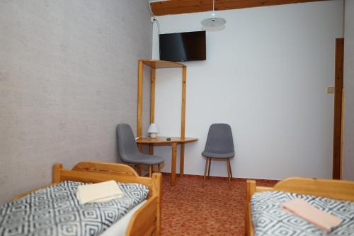 a room with two beds and a table and two chairs at Penzion Terasa, bed & breakfast in Velké Losiny