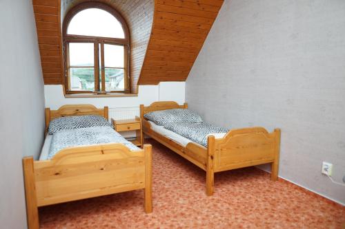 a room with three beds and a window at Penzion Terasa, bed & breakfast in Velké Losiny