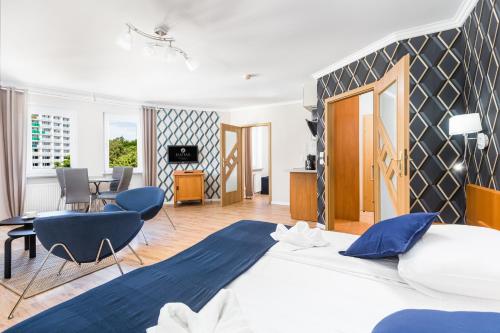 コウォブジェクにあるJantar Apartamenty Sunny Olymp Iのベッドルーム(大型ベッド1台付)、リビングルームが備わります。