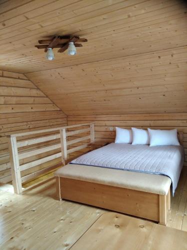 een slaapkamer met een bed in een houten hut bij Катерина in Rozhanka Nizhnyaya