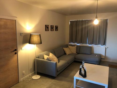 a living room with a couch and a table at 't schotje in Ledegem