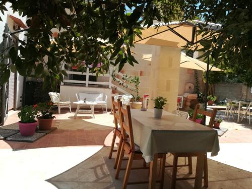 a patio with a table and chairs and an umbrella at Antico Casale Il Sambuco in Manduria