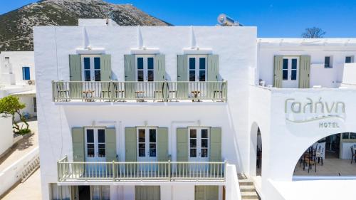 a white building with green shutters and a balcony at Hotel Galini Sifnos in Apollonia