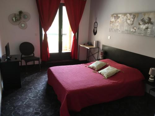 a bedroom with a red bed and a window at Résidence Le Grand Virage in Pont-de-Labeaume