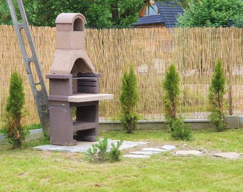 a stone bird feeder in a yard next to a fence at TatryTop Osada Gazdówka z sauną in Kościelisko