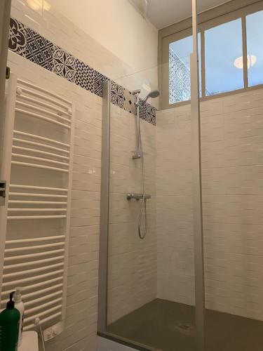 une douche avec une porte vitrée dans une salle de bain dans l'établissement Gîte La Maison du Moulin de Sologne, à Pruniers