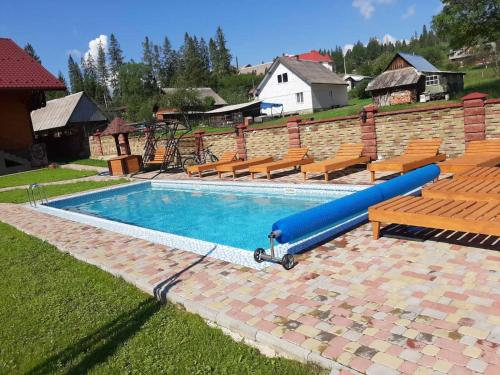 a pool with a blue slide in a yard at Садиба у Кіри in Slavske
