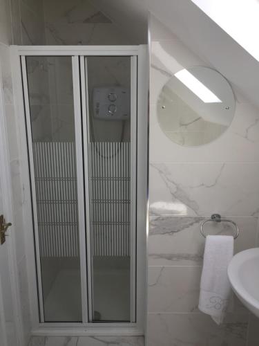 y baño con ducha acristalada y lavamanos. en St Anthony's Rosslare Strand, en Mervyn