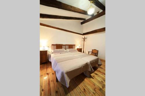 sypialnia z dużym łóżkiem i drewnianą podłogą w obiekcie Piedra Andadera II w mieście Soria