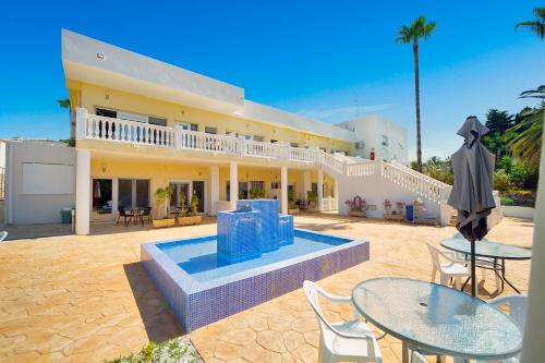 a house with a pool and tables and chairs at Aparthotel Carrio Sol - Monty´s in Calpe