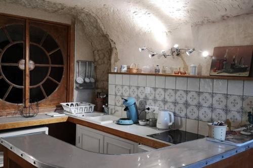 eine Küche mit einer Theke, einer Spüle und einem Weinfass in der Unterkunft Caves du coteau 1 in Lunay