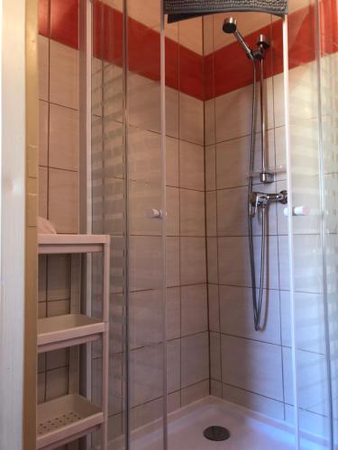 une douche avec une porte vitrée dans une salle de bain dans l'établissement Kwatery prywatne pokoje i apartament JOANNA w Grzybowie, à Grzybowo