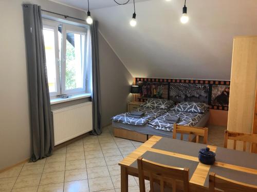 une chambre avec un lit, une table et une fenêtre dans l'établissement Kwatery prywatne pokoje i apartament JOANNA w Grzybowie, à Grzybowo