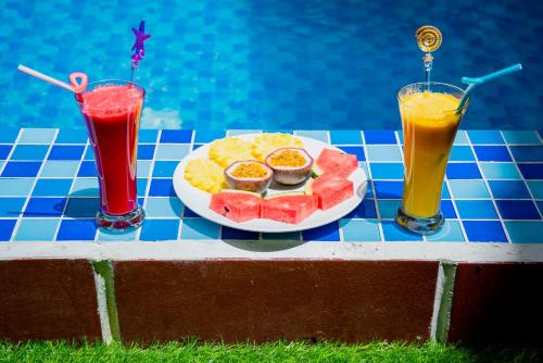 a plate of food on a table next to two drinks at Green Hill Hotel in Hoi An