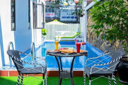 a table with a plate of food on a patio at Green Hill Hotel in Hoi An