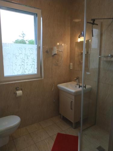 クリニツァ・モルスカにあるLaguna Bałtyckaのバスルーム(洗面台、窓付きシャワー付)