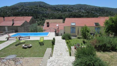 a backyard with a swimming pool and a house at Holiday Home Stari Zoganj in Potomje