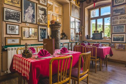 a restaurant with tables and chairs with pink tablecloths at Hotel Pelikan in Virpazar