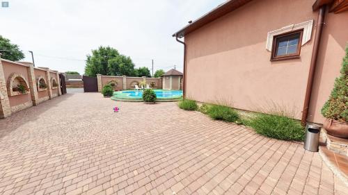 a courtyard with a swimming pool next to a building at Пансіонат Маленька Квітка Kis Virág Panzió in Velyka Bihanʼ