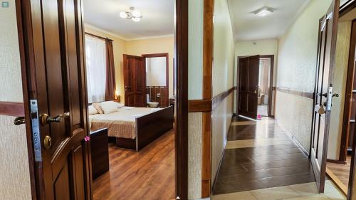 a room with a bed and a door to a bedroom at Пансіонат Маленька Квітка Kis Virág Panzió in Velyka Bihanʼ