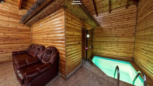 a room with a bath tub in a wooden room at Пансіонат Маленька Квітка Kis Virág Panzió in Velyka Bihanʼ