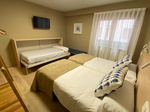 a hotel room with two beds and a window at Hotel Baltico 2 estrellas in Luarca
