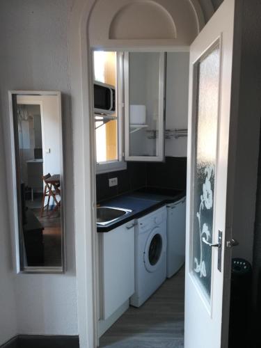 une cuisine avec un évier et une machine à laver dans l'établissement Charmant studio climatisé centre Villefranche sur mer, à Villefranche-sur-Mer