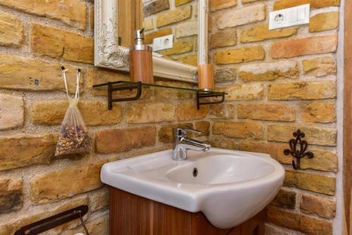 a bathroom with a sink and a brick wall at Country Home in Ventspils