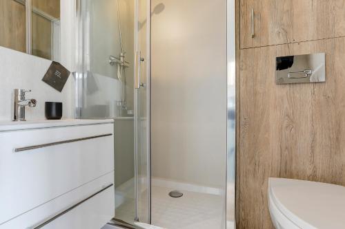 uma casa de banho com um chuveiro, um WC e um lavatório. em Luxe Houseboat Skoft em Grou