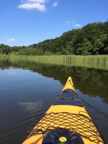 a person paddling a yellow kayak on a river at Matilda I-die außergewöhnliche Finnhütte in Ahrensberg