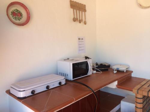 a microwave sitting on top of a wooden table at Quarto em Monte Alentejano perto do Cercal in Cercal