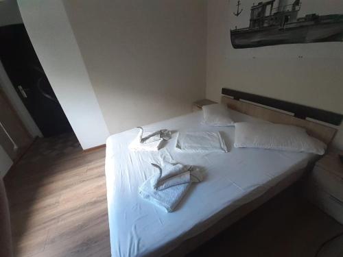 Una cama con sábanas blancas y toallas. en Delta ca Odinioara, en Sulina