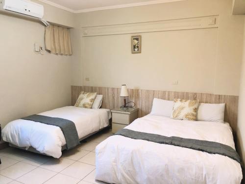 two beds sitting next to each other in a bedroom at Xin Homestay in Luodong