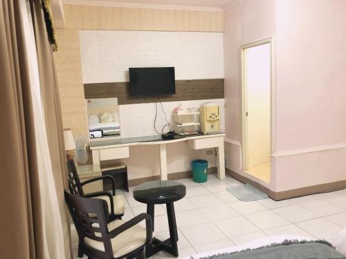 a room with a desk with a computer and chairs at Yun’s Homestay in Luodong