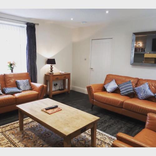 a living room with two couches and a coffee table at Amble Holiday Home in Amble