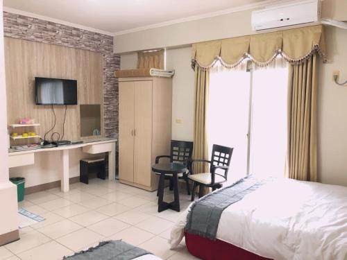 a hotel room with a bed and a table and chairs at Xin Homestay in Luodong