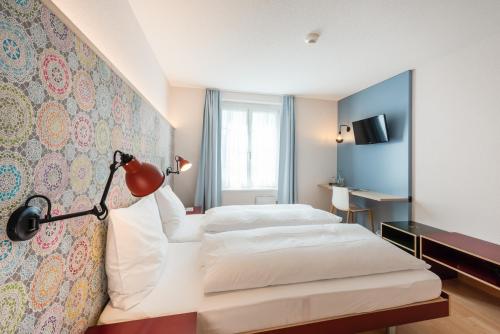 a hotel room with two beds and a lamp at Bären Self Check-in Hotel in Solothurn