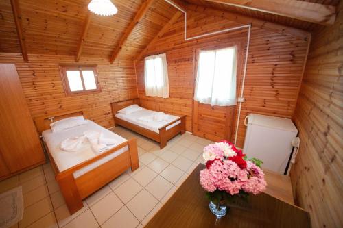 a room with two beds in a log cabin at Lodges Shen Nikolla in Dhërmi