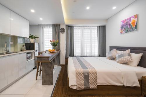a bedroom with a large bed and a kitchen at Narcissus Hotel & Apartment in Hanoi