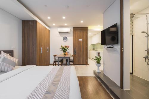 a hotel room with a bed and a flat screen tv at Narcissus Hotel & Apartment in Hanoi