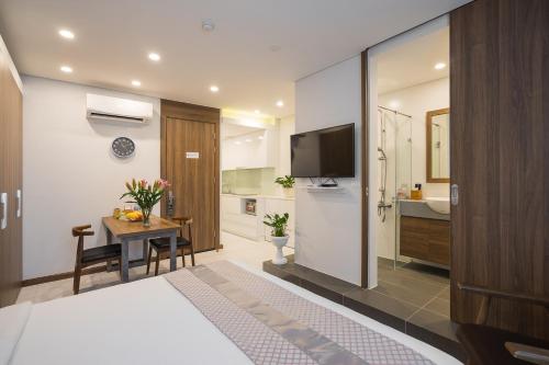a hotel room with a bed and a table and a television at Narcissus Hotel & Apartment in Hanoi