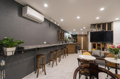 a restaurant with a bar with chairs and tables at Narcissus Hotel & Apartment in Hanoi