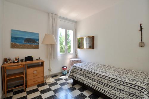 a bedroom with a bed and a desk and a window at Villa Cala Trons in Lloret de Mar