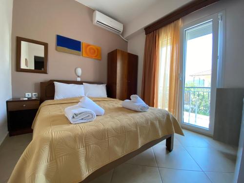 a bedroom with a bed with two towels on it at Maritsa's Rooms in Stavros